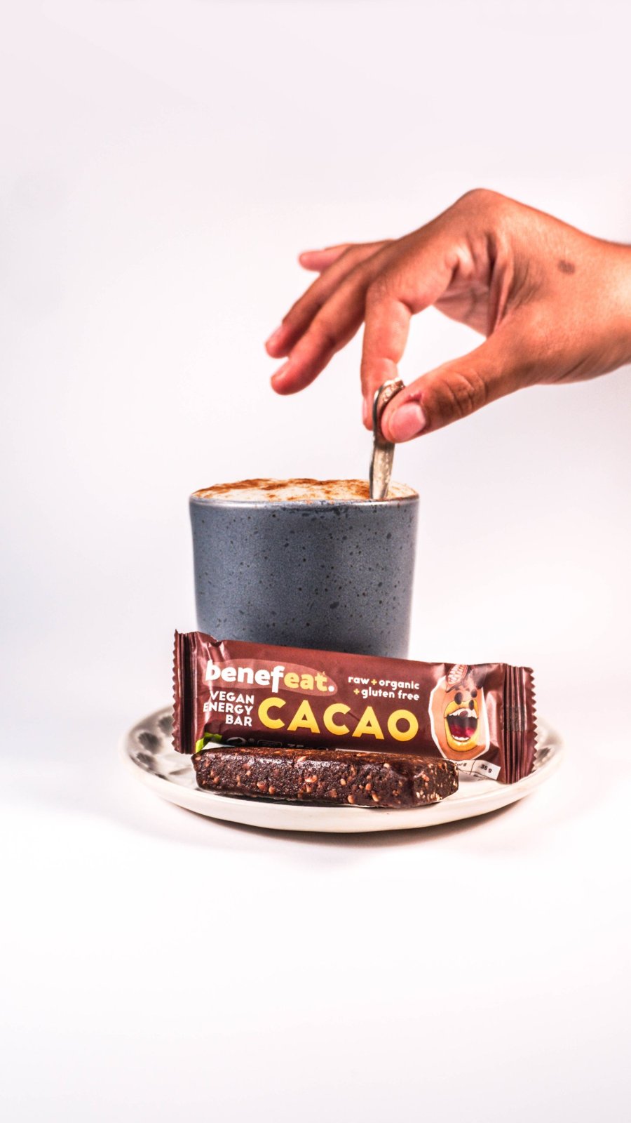 Cacao bar on a saucer next to a cappuccino