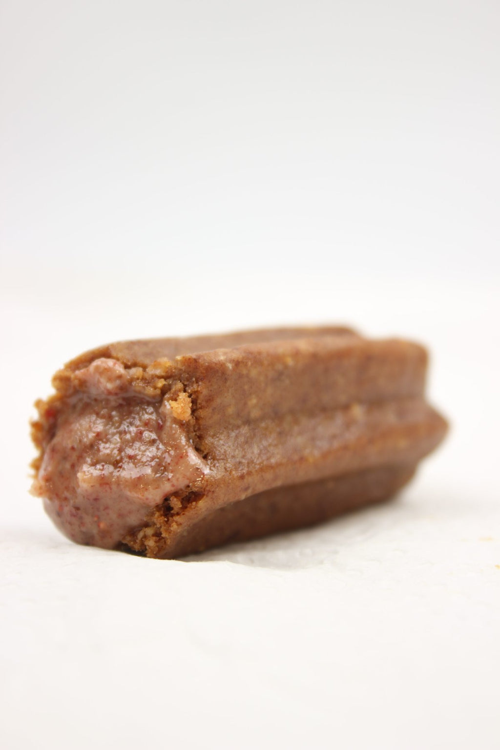 Close-up of an almond churro with its strawberry filling