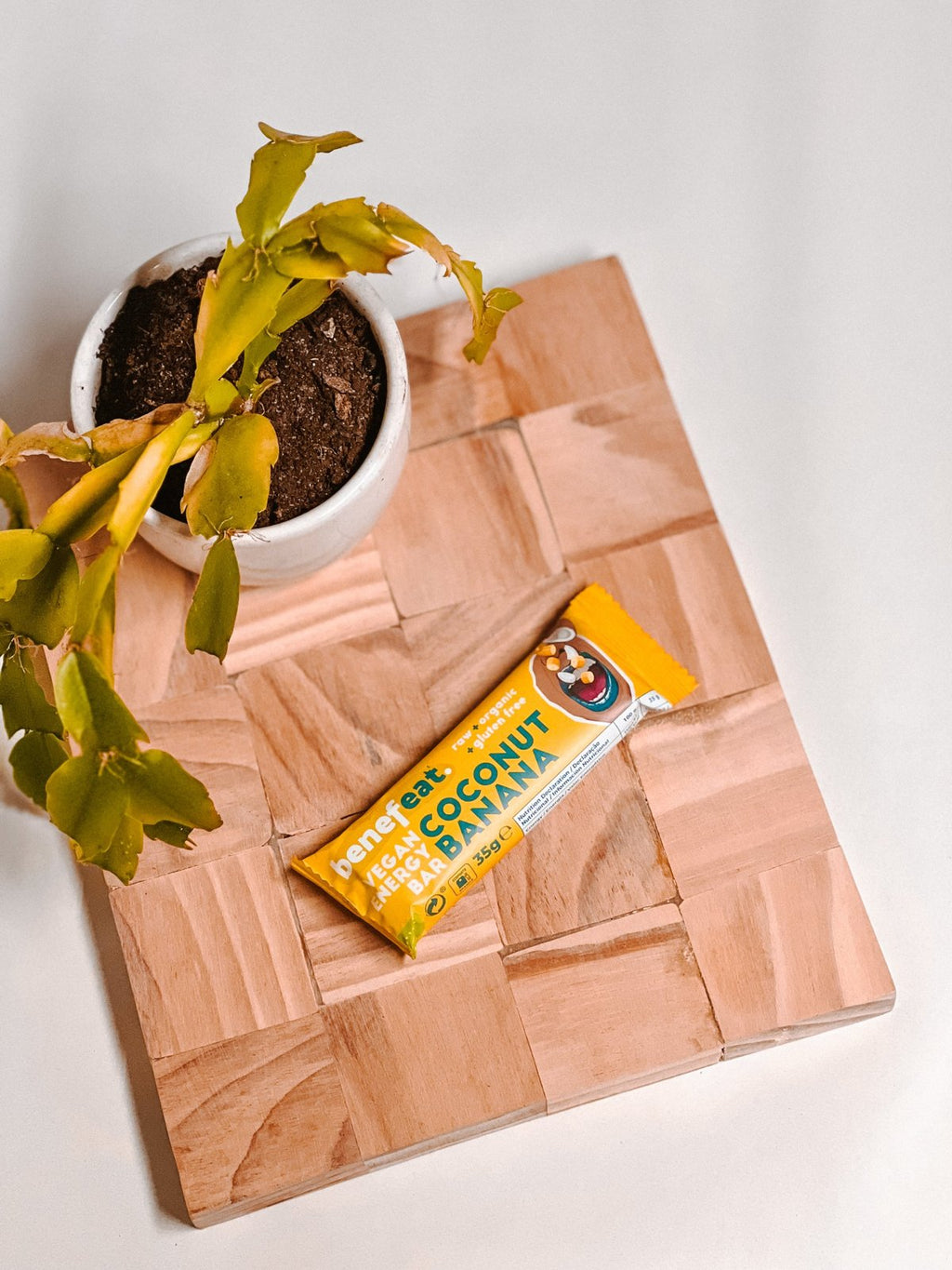 Coconut Banana bar on a wooden board next to a plant